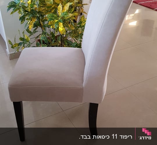 כיסא מרופד בצבע בהיר עם רגליים כהות